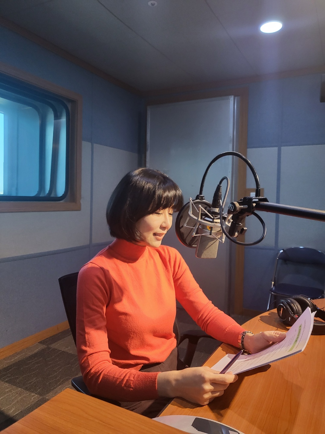 방송 원고를 확인하며 라디오에 출연하는 김현희 본부장